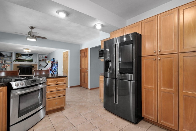 6146 Catawba Dr, Grove City, OH 43123 - kitchen featuring stainless steel appliances, a fireplace, dark countertops, light tile patterned flooring, and ceiling fan