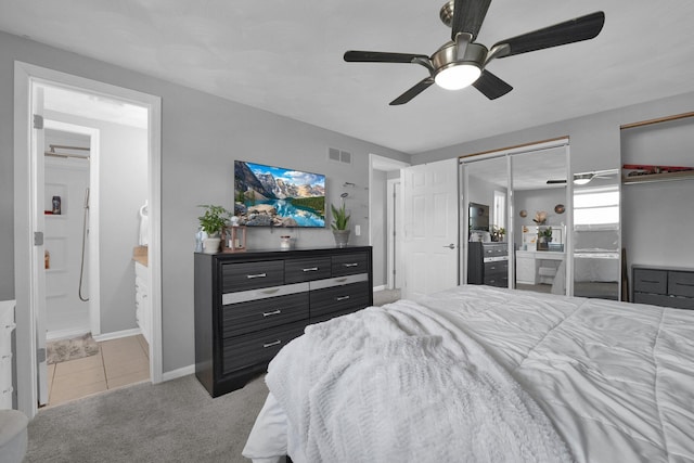 6146 Catawba Dr, Grove City, OH 43123 - carpeted bedroom featuring multiple closets, connected bathroom, a ceiling fan, and tile patterned flooring
