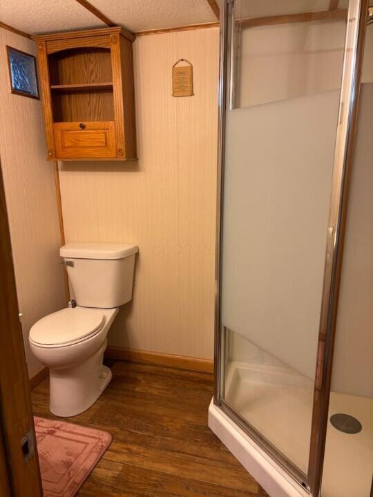 521 Kenton Galion Rd E, Marion, OH 43302 - full bath featuring a stall shower, wood finished floors, and a textured ceiling