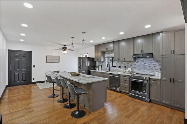 10123 Loop Rd, Millersport, OH 43046 - kitchen featuring stainless steel stove, black dishwasher, refrigerator with ice dispenser, a breakfast bar, and a ceiling fan