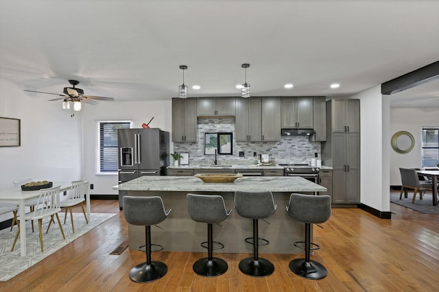 10123 Loop Rd, Millersport, OH 43046 - kitchen with stainless steel appliances, decorative backsplash, a breakfast bar, gray cabinetry, and recessed lighting