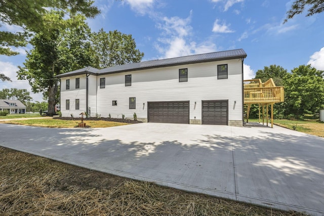 10123 Loop Rd, Millersport, OH 43046 - view of front of property featuring an attached garage, concrete driveway, a deck, and a metal roof