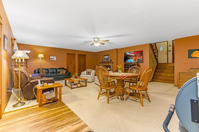 976 Hillside Dr, Newark, OH 43055 - dining area with a ceiling fan, stairway, a fireplace, and light wood-style flooring