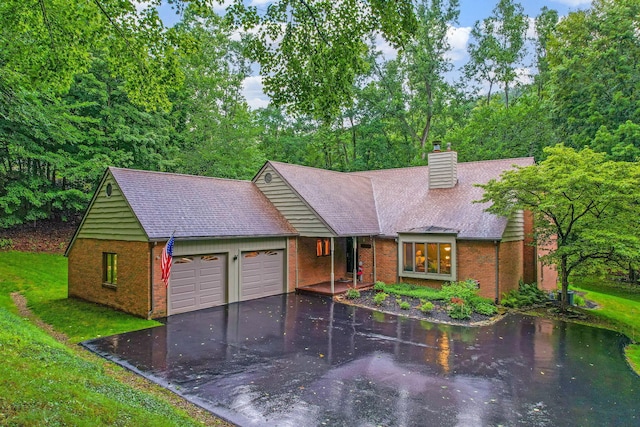 976 Hillside Dr, Newark, OH 43055 - view of front of house with brick siding, a garage, driveway, and a chimney