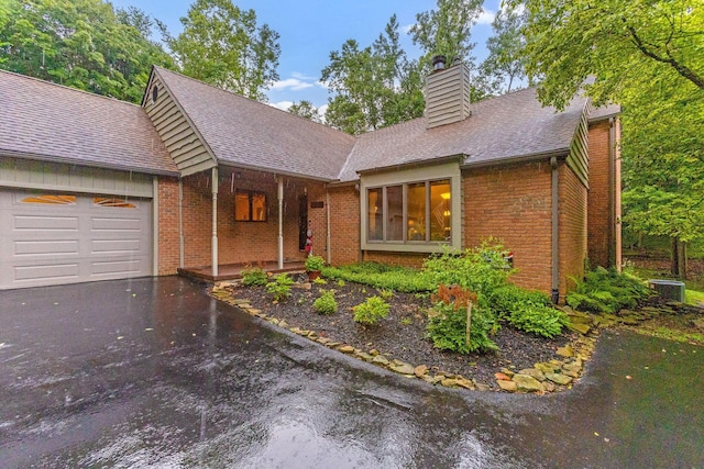 976 Hillside Dr, Newark, OH 43055 - view of front of home featuring brick siding, a chimney, a garage, asphalt driveway, and a shingled roof