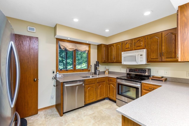 976 Hillside Dr, Newark, OH 43055 - kitchen featuring stainless steel appliances, brown cabinetry, light countertops, and recessed lighting