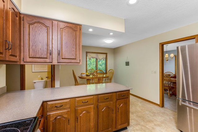 976 Hillside Dr, Newark, OH 43055 - kitchen featuring freestanding refrigerator, a peninsula, recessed lighting, and brown cabinets
