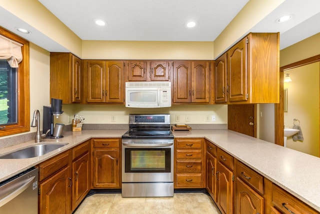 976 Hillside Dr, Newark, OH 43055 - kitchen with appliances with stainless steel finishes, brown cabinets, light countertops, light tile patterned floors, and recessed lighting