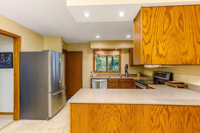 976 Hillside Dr, Newark, OH 43055 - kitchen featuring appliances with stainless steel finishes, brown cabinets, a peninsula, light countertops, and recessed lighting