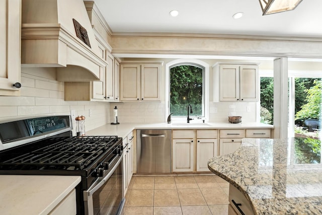 371 Ashworth Ct, Dublin, OH 43017 - kitchen with appliances with stainless steel finishes, light tile patterned flooring, decorative backsplash, custom exhaust hood, and light stone countertops