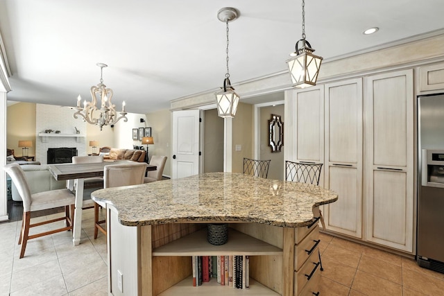 371 Ashworth Ct, Dublin, OH 43017 - kitchen with light tile patterned floors, stainless steel fridge, a center island, a chandelier, and cream cabinets