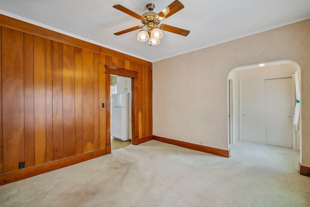 126 Dix Ave, Marion, OH 43302 - empty room featuring carpet floors, arched walkways, ceiling fan, ornamental molding, and wood walls