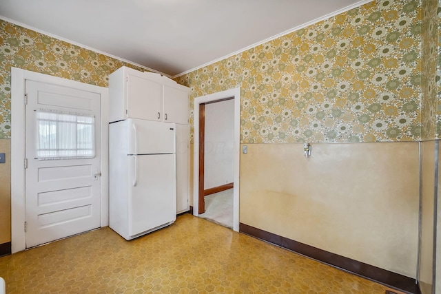 126 Dix Ave, Marion, OH 43302 - kitchen featuring wallpapered walls, light flooring, freestanding refrigerator, crown molding, and white cabinets