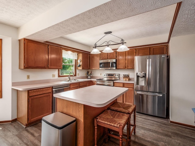 238 Key Blvd, Pataskala, OH 43062 - kitchen featuring appliances with stainless steel finishes, dark wood-style floors, a textured ceiling, light countertops, and a center island