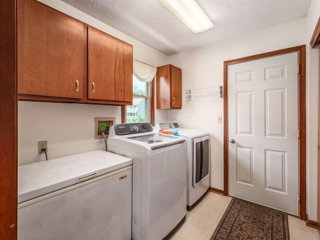 238 Key Blvd, Pataskala, OH 43062 - laundry room with cabinet space, washing machine and clothes dryer, a textured ceiling, and light tile patterned floors