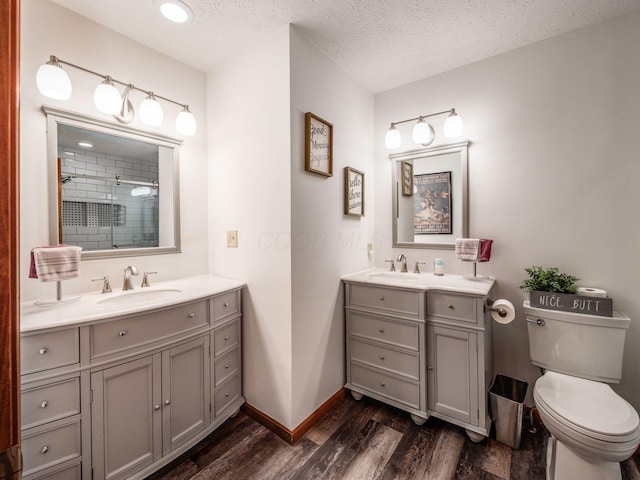 238 Key Blvd, Pataskala, OH 43062 - bathroom with vanity, wood finished floors, a tile shower, and a textured ceiling