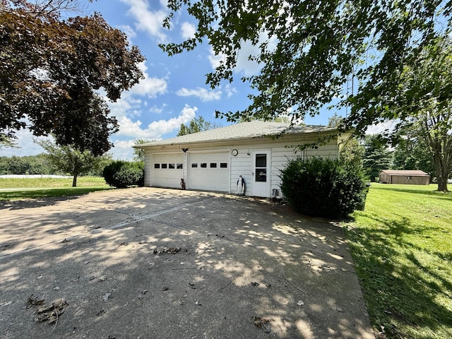 403 N Columbus St, Somerset, OH 43783 - view of property exterior featuring an outbuilding, concrete driveway, a lawn, and an attached garage