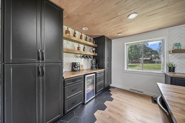 620 Fleetrun Ave, Columbus, OH 43230 - indoor dry bar featuring beverage cooler, wood ceiling, tasteful backsplash, wood finished floors, and recessed lighting