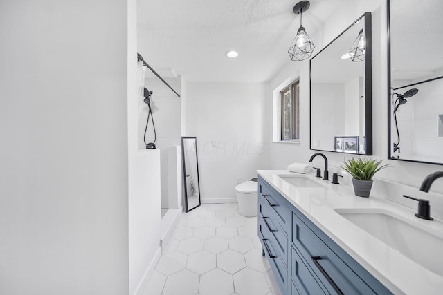 620 Fleetrun Ave, Columbus, OH 43230 - bathroom featuring a shower, double vanity, tile patterned floors, a textured ceiling, and recessed lighting