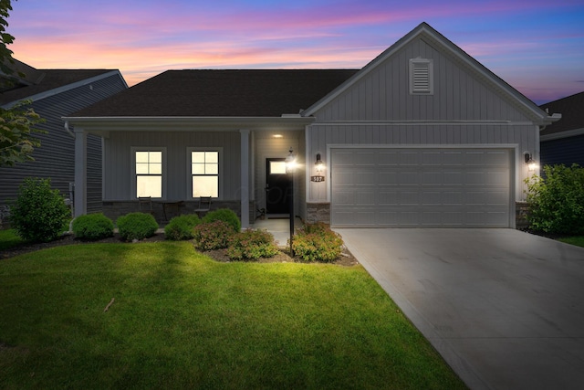 507 Curry Dr, Pataskala, OH 43062 - view of front of home with an attached garage, a lawn, driveway, board and batten siding, and stone siding