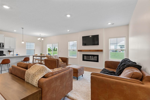 507 Curry Dr, Pataskala, OH 43062 - living area featuring a chandelier, a glass covered fireplace, light wood-style floors, and recessed lighting