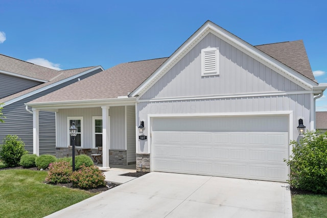 507 Curry Dr, Pataskala, OH 43062 - view of front of property with roof with shingles, a garage, concrete driveway, covered porch, and stone siding