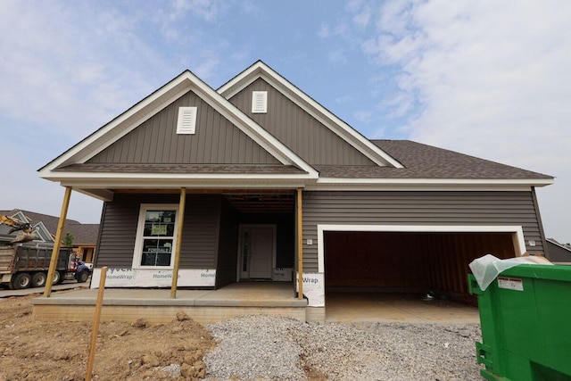 3004 Darby Downs Rd, Grove City, OH 43123 - view of front facade with covered porch, a garage, roof with shingles, board and batten siding, and gravel driveway