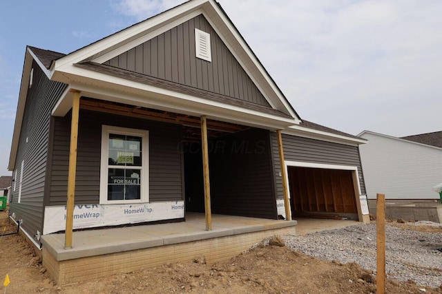 3004 Darby Downs Rd, Grove City, OH 43123 - view of front facade featuring board and batten siding, a porch, an attached garage, and gravel driveway