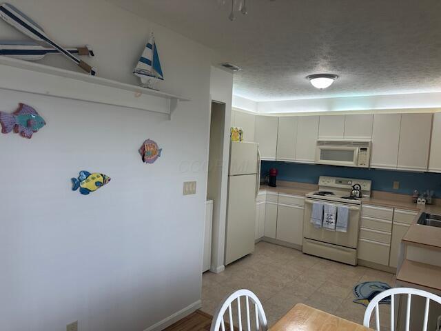 241 Chase Ave Unit B1L, Russells Point, OH 43348 - kitchen featuring white appliances, light countertops, and white cabinets