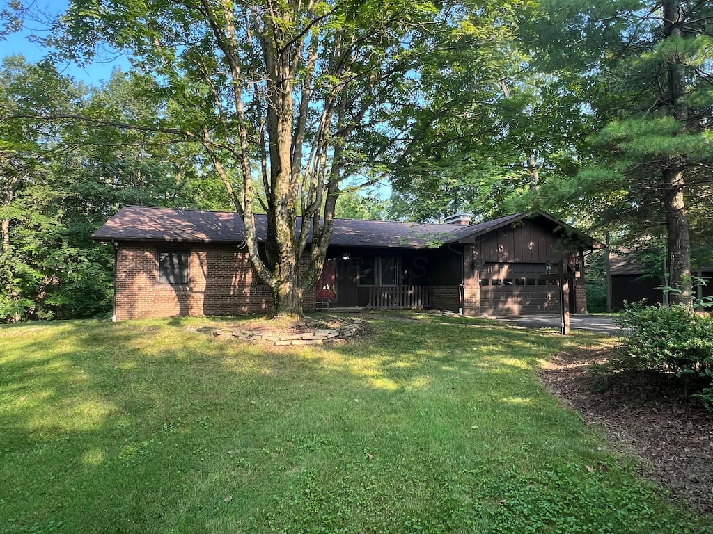 3502 Hazelton Etna Rd, Alexandria, OH 43001 - back of house with a yard, a garage, brick siding, a chimney, and driveway