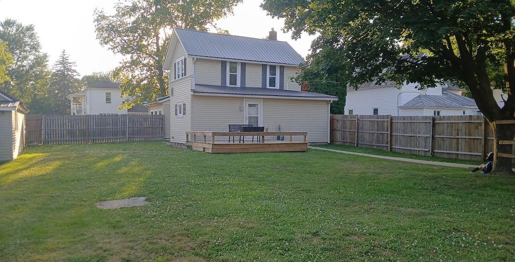 316 N High St, Caledonia, OH 43314 - rear view of house featuring a fenced backyard, a metal roof, and a wooden deck