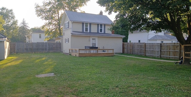 316 N High St, Caledonia, OH 43314 - rear view of house featuring a fenced backyard, a metal roof, and a wooden deck
