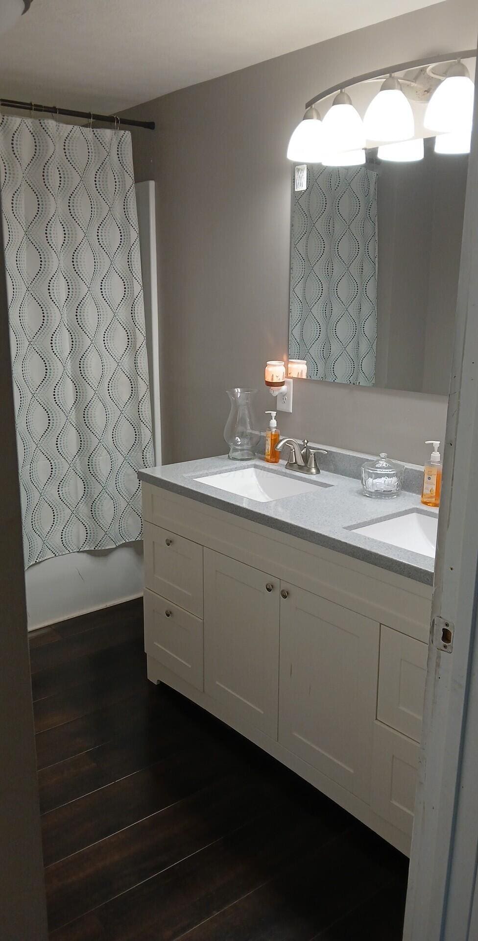 316 N High St, Caledonia, OH 43314 - bathroom with vanity, wood finished floors, and curtained shower