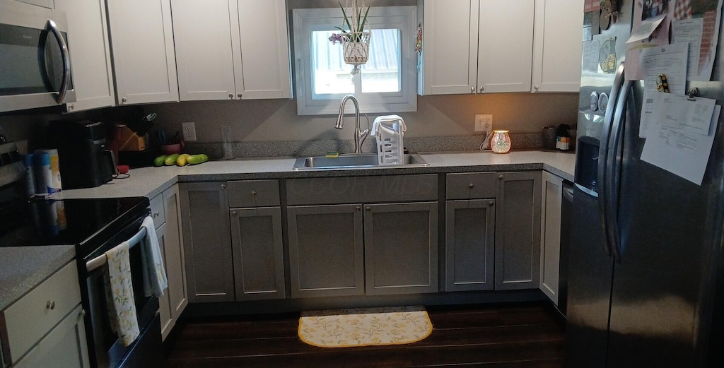 316 N High St, Caledonia, OH 43314 - kitchen with appliances with stainless steel finishes, light countertops, and dark wood-type flooring