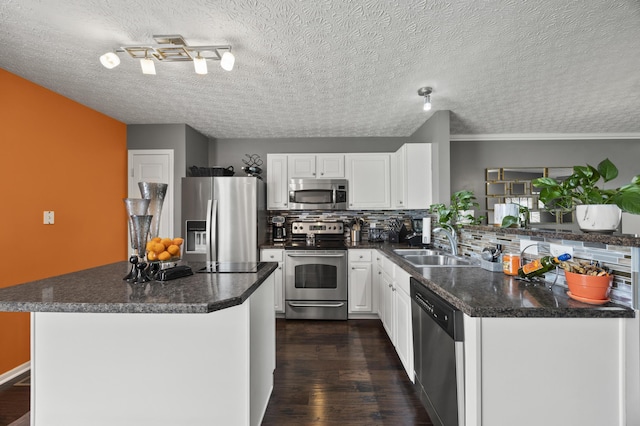 5466 Bull Creek Dr Unit 101, Dublin, OH 43016 - kitchen featuring stainless steel appliances, tasteful backsplash, dark countertops, white cabinets, and a textured ceiling