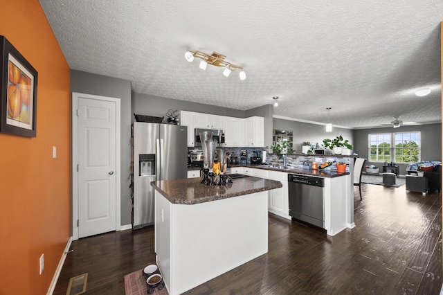 5466 Bull Creek Dr Unit 101, Dublin, OH 43016 - kitchen featuring stainless steel appliances, a peninsula, dark wood finished floors, white cabinets, and open floor plan