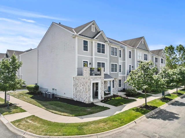 5466 Bull Creek Dr Unit 101, Dublin, OH 43016 - view of side of home featuring stone siding and a yard