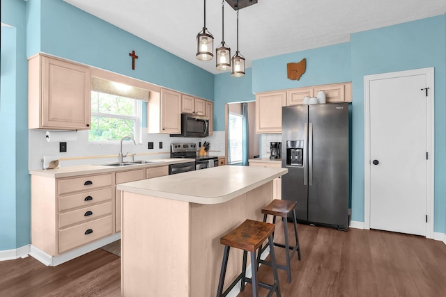 8512 Squad Dr, Galloway, OH 43119 - kitchen featuring appliances with stainless steel finishes, dark wood-style flooring, a center island, light countertops, and a breakfast bar