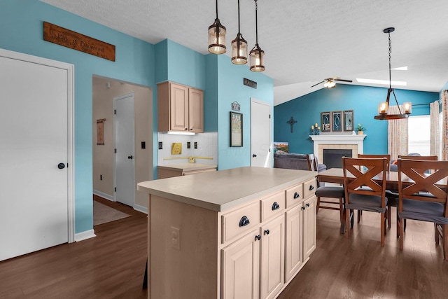 8512 Squad Dr, Galloway, OH 43119 - kitchen featuring dark wood-style flooring, a fireplace, ceiling fan, lofted ceiling, and a kitchen island