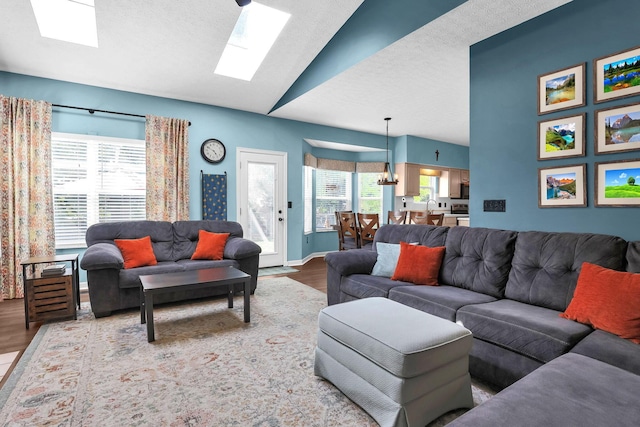 8512 Squad Dr, Galloway, OH 43119 - living area with wood finished floors, a skylight, vaulted ceiling, and a textured ceiling