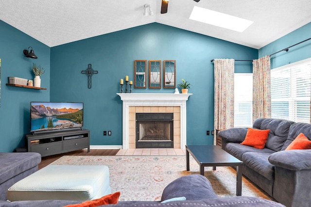 8512 Squad Dr, Galloway, OH 43119 - living room with vaulted ceiling, a skylight, ceiling fan, wood finished floors, and a tile fireplace