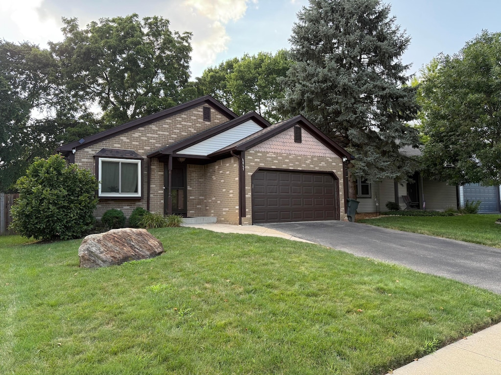 6069 Hildenboro Dr, Dublin, OH 43017 - view of front of property with an attached garage, brick siding, driveway, and a front yard