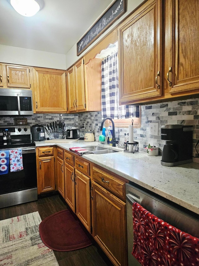 112 N George St, Lancaster, OH 43130 - kitchen featuring appliances with stainless steel finishes, decorative backsplash, dark wood-style floors, and brown cabinets