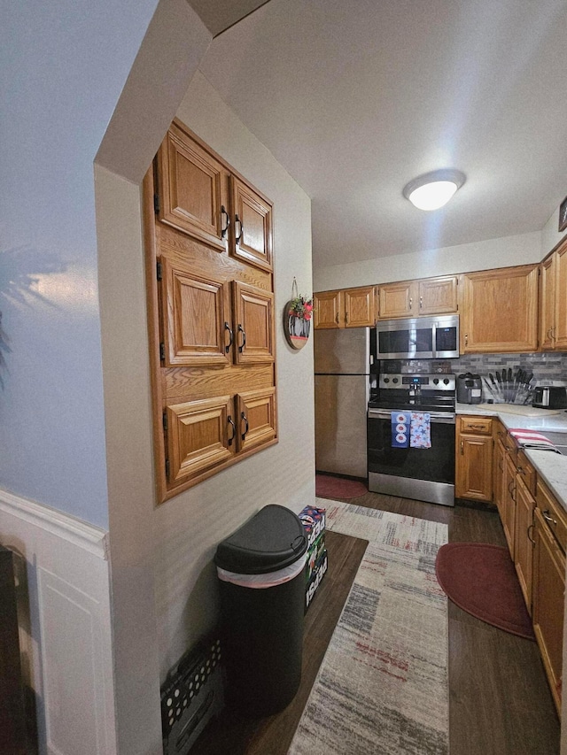 112 N George St, Lancaster, OH 43130 - kitchen featuring stainless steel appliances, light countertops, tasteful backsplash, dark wood-style flooring, and brown cabinets