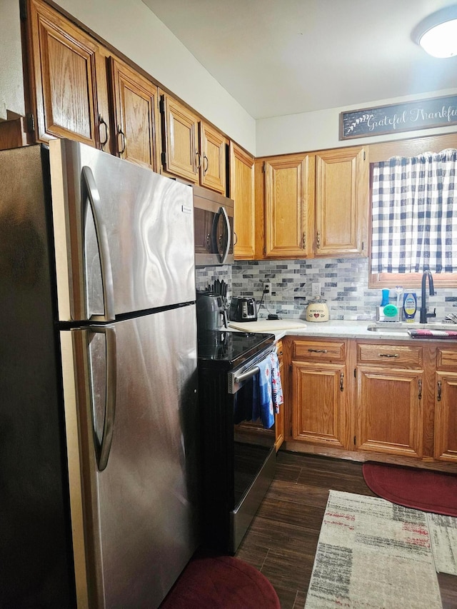 112 N George St, Lancaster, OH 43130 - kitchen featuring stainless steel appliances, light countertops, dark wood-style flooring, backsplash, and brown cabinets
