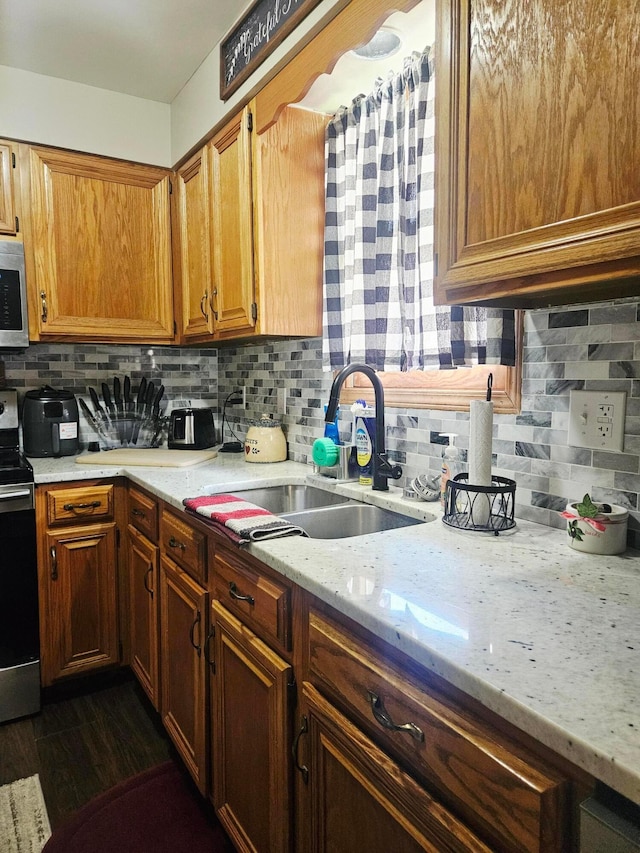 112 N George St, Lancaster, OH 43130 - kitchen with stainless steel appliances, decorative backsplash, and brown cabinetry