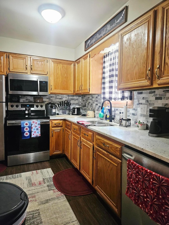 112 N George St, Lancaster, OH 43130 - kitchen featuring stainless steel appliances, tasteful backsplash, dark wood-type flooring, light stone counters, and brown cabinets