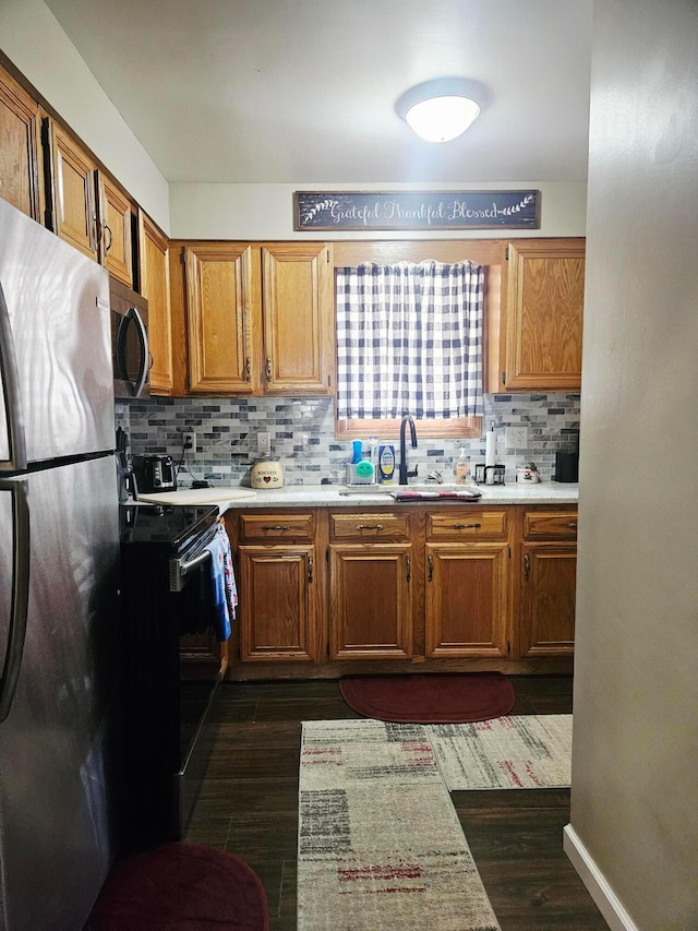 112 N George St, Lancaster, OH 43130 - kitchen with appliances with stainless steel finishes, decorative backsplash, dark wood-style flooring, and light countertops