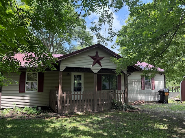 206 William St, Fulton, OH 43321 - bungalow featuring a porch, a front lawn, and a metal roof
