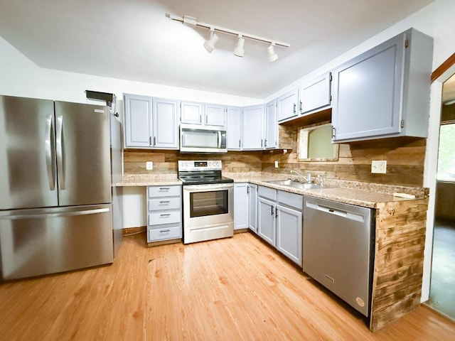206 William St, Fulton, OH 43321 - kitchen featuring appliances with stainless steel finishes, light wood-style floors, rail lighting, and gray cabinets